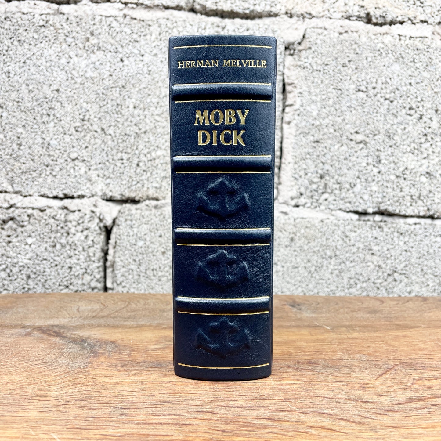 Handgefertigte Ledereinband-Ausgabe von Moby Dick von Herman Melville in dunkelblauem Leder mit goldenen Prägungen, Anker- und Steuerrad-Reliefs sowie stilisierter Lederintarsie des weißen Wals, hergestellt von annabuchwunder.