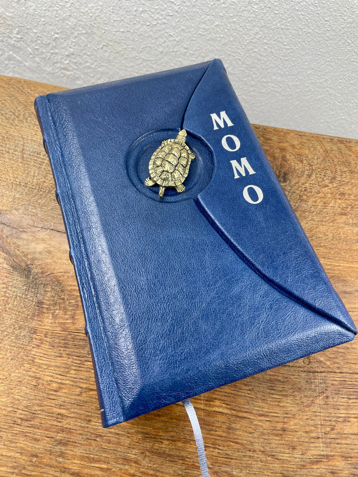 Handgebundenes Lederbuch Momo mit magnetischer Klappe und Messingschildkröte Kassiopeia.