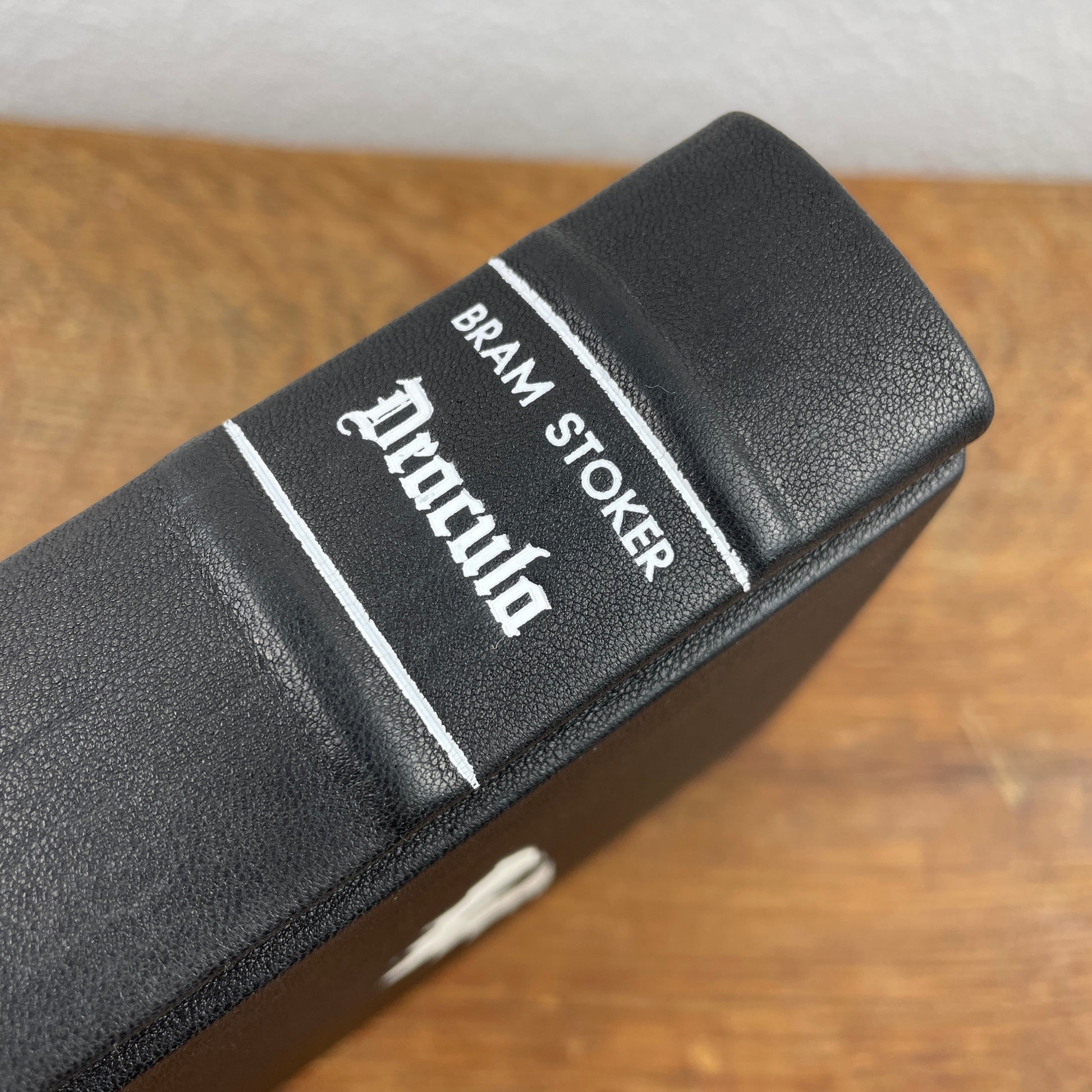 Einband von Dracula mit weißer Titelprägung und antiker Frakturschrift auf schwarzem Leder